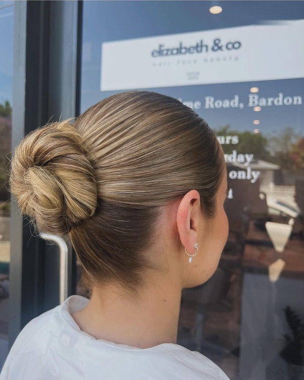 Sleek low bun with a smooth, polished finish