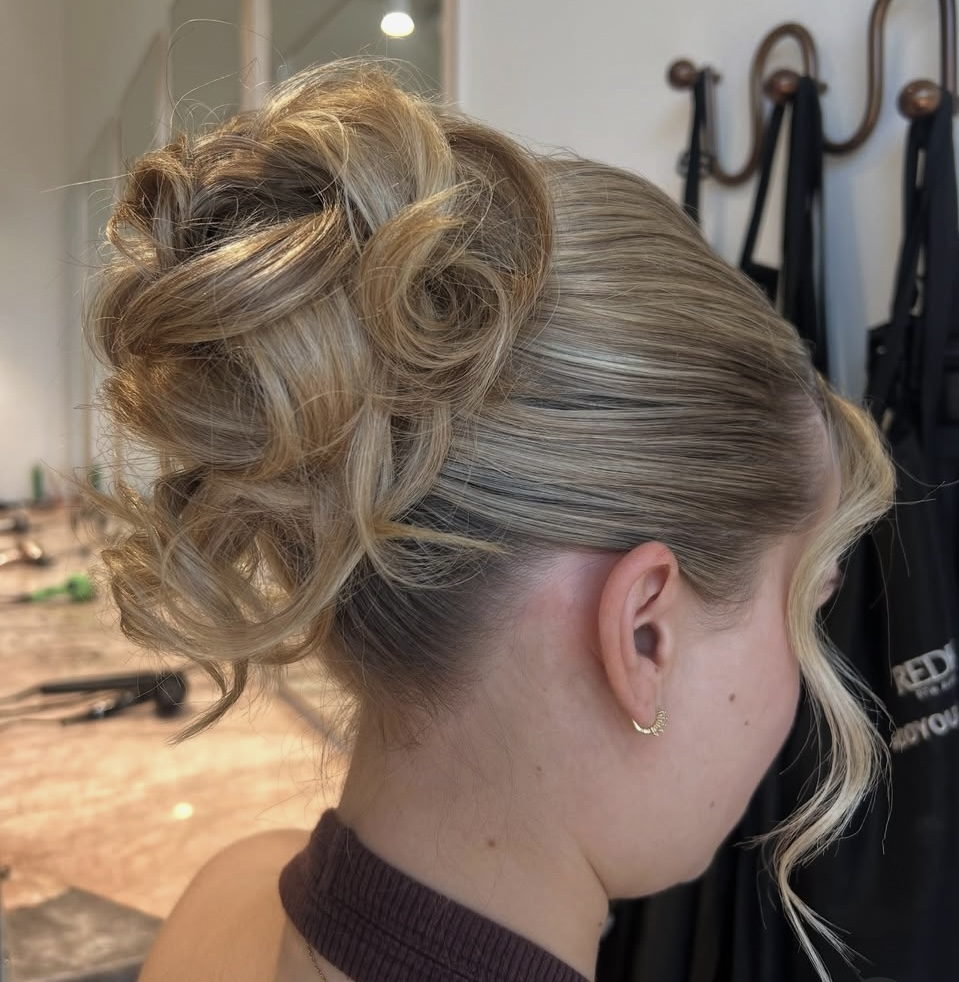 Soft curled blonde upstyle with face-framing tendrils